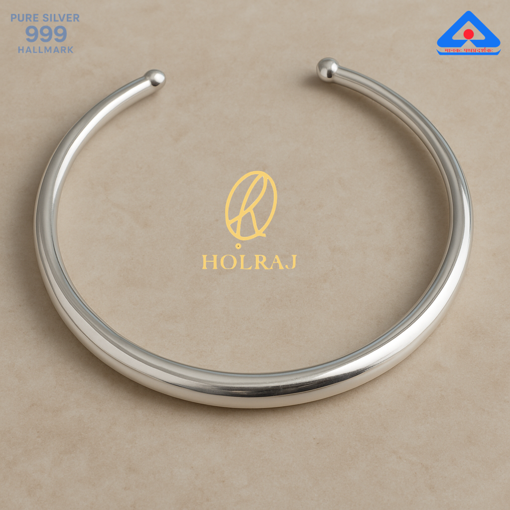 Aarohi Hansuli by Holraj, smooth pure 999 silver choker necklace with polished finish resting on a modern beige tabletop.