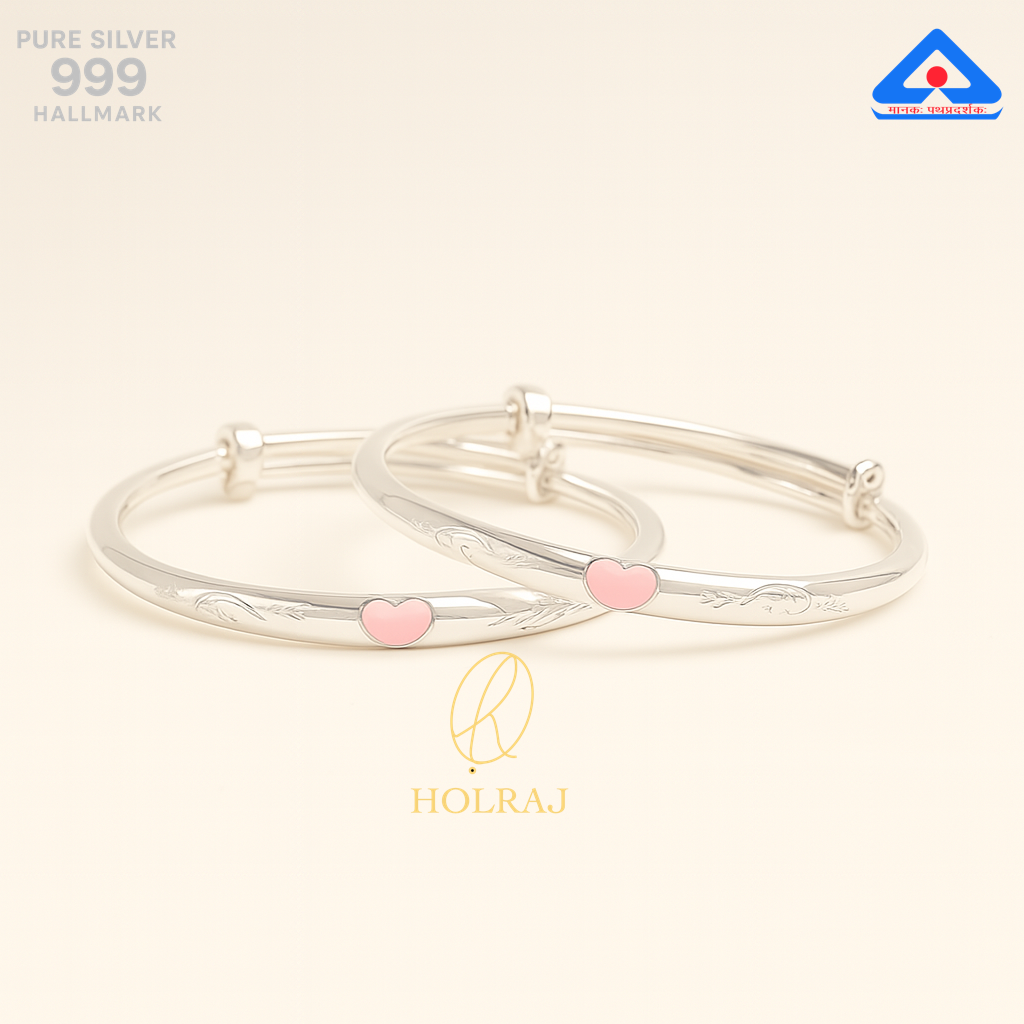 Pair of pure 999 silver baby bangles with soft pink heart accents and adjustable ends, displayed on a neutral background.