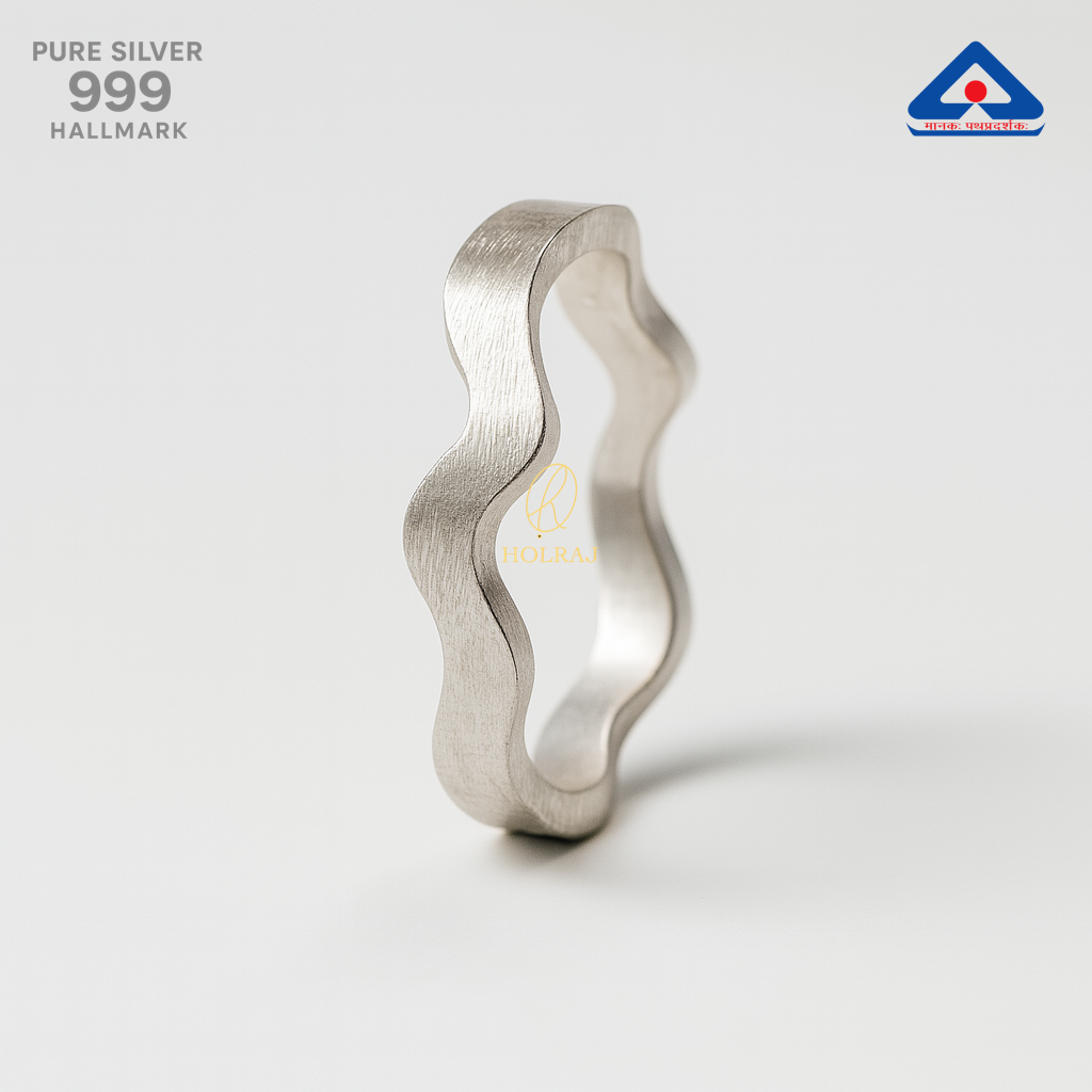 Silver ring with wavy design on a light gray background, featuring 'PURE SILVER 999' and hallmark details.
