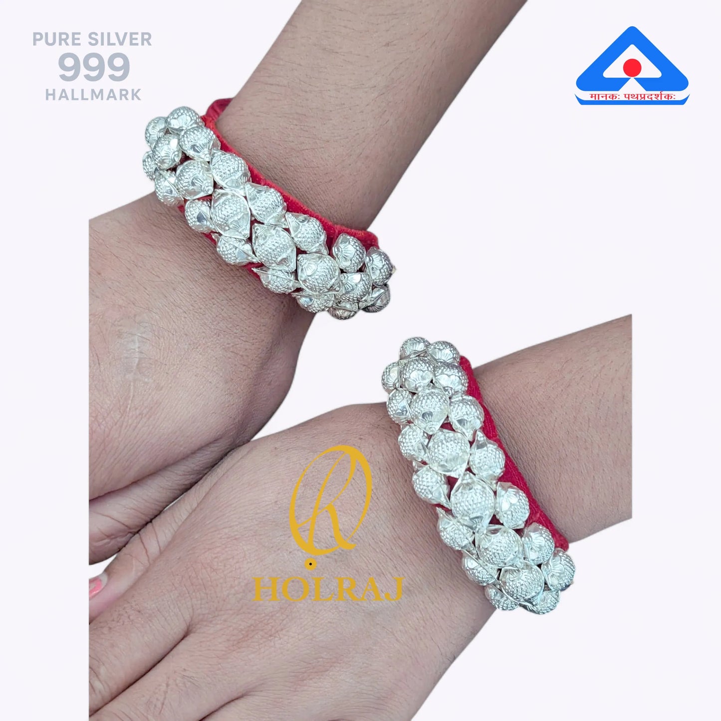 Holraj branded 999 purity Silver Raj Ponchi with red cord on a wrist.