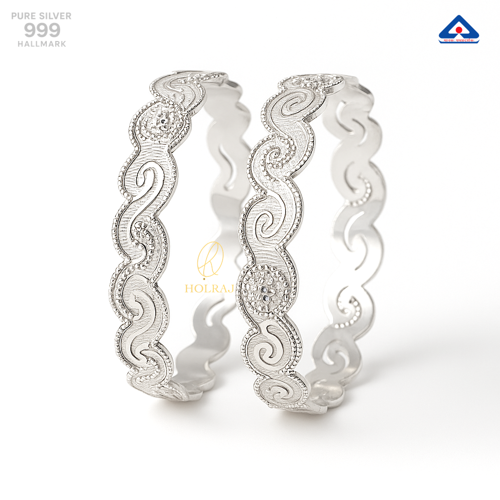 Pair of traditional 999 pure silver bangles with wavy contours, paisley designs, and high-polish finish, displayed on a clean white background - by Holraj