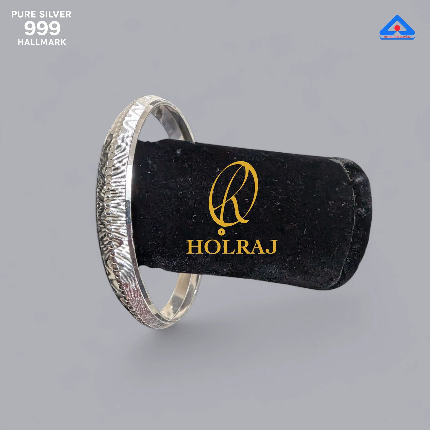 Holraj branded Silver bangle on a black pillow with gray background