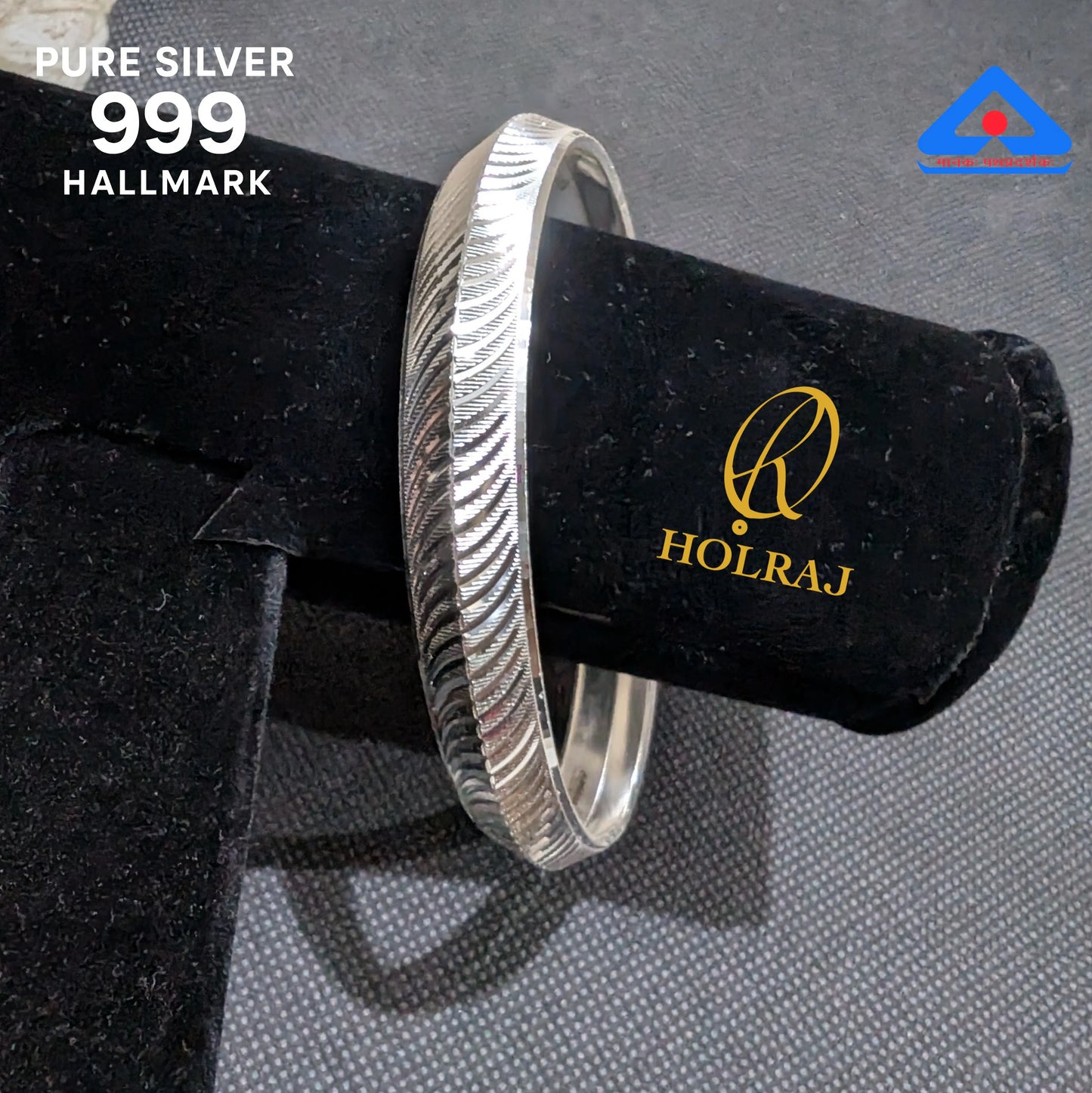 Silver kada of 99.9% silver purity on a black velvet cushion with Holraj logo, against a gray background.