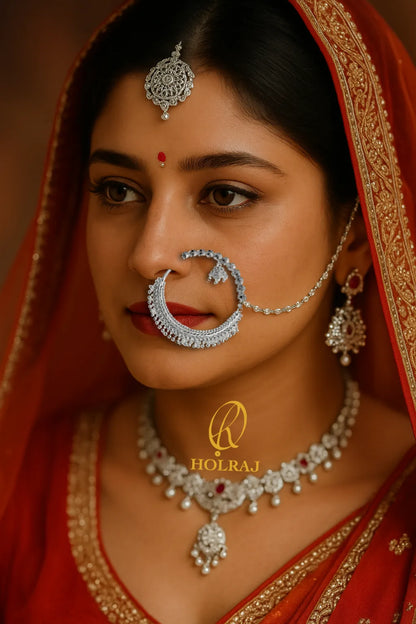Woman wearing silver jewellery with a red dupatta, prominently featuring traditional Aarti Nath by Holraj brand in 999 pure hallmark silver.