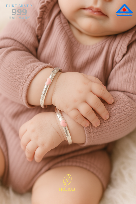 Baby wearing holraj branded BIS Hallmark 999 pure silver bracelets with a pink heart
