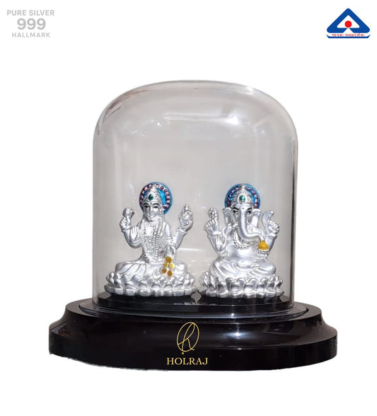 Silver statues of Lakshmi and Ganesha in a clear dome.