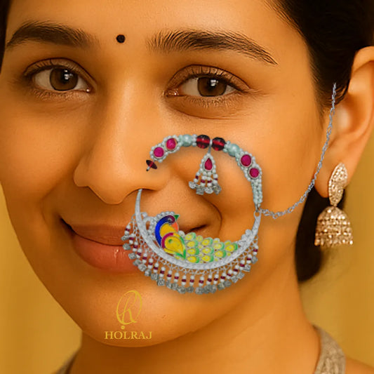 Close-up of a woman wearing BIS Hallmarked 999 pure silver elaborate Tehri Nath or Nathuli or traditional pahadi Nosering with colorful peacock enamel and beads, inspired by Uttarakhand’s bridal jewelry.