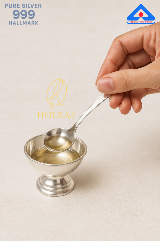 Hand using 999 silver charanamrit spoon in puja