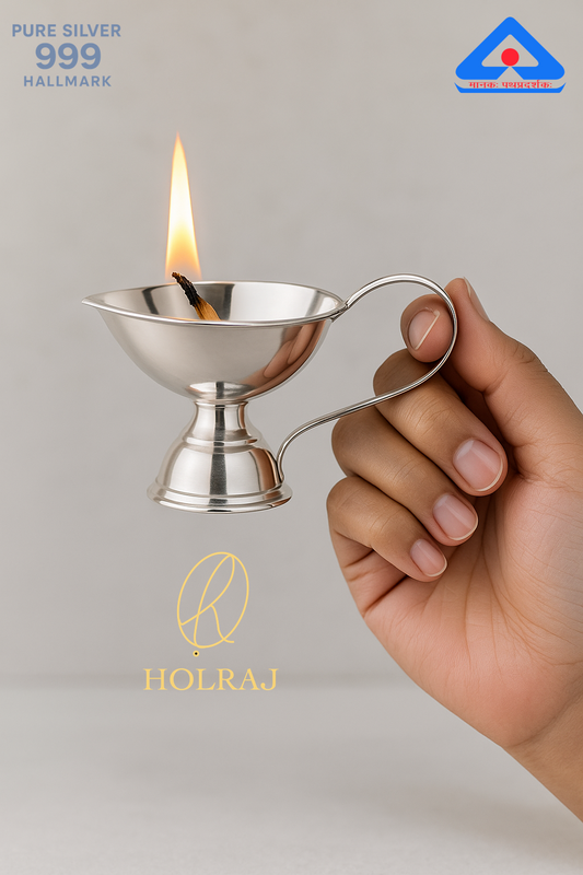 Hand holding a Holraj branded BIS hallmark 999 pure silver lamp with a handle.
