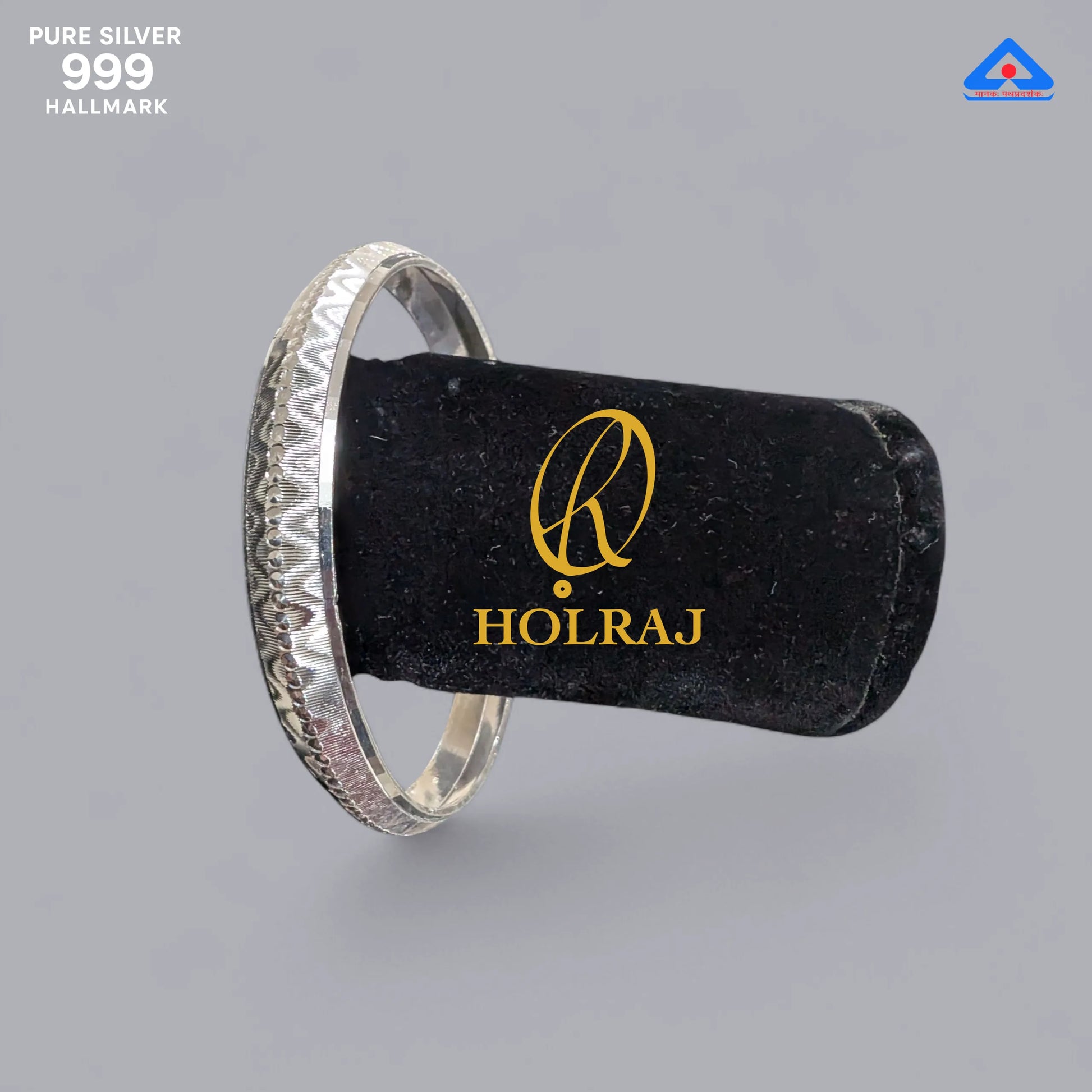 Holraj branded Silver bangle on a black pillow with gray background