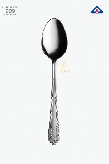 Pure silver spoon with ornate handle design on white background – 999 hallmark certified. By Holraj
