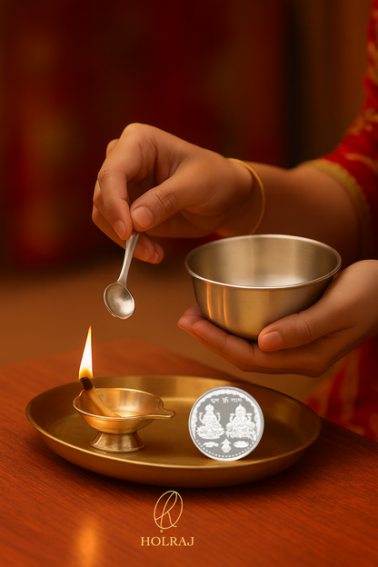 Person holding BIS Hallmark 999 pure silver bowl and spoon over a 999 Silver oil lamp with a coin on a wooden surface, featuring the brand 'HOLRAJ'.