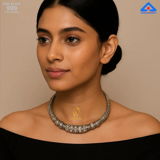 A modern woman wearing a black gown and Holraj branded Crescent-shaped 999 pure silver vintage Tribal Hansuli necklace choker.