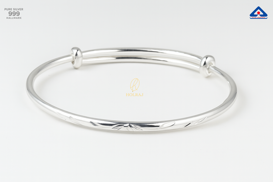 A close-up image of the NoorLeaf™ Pure Silver Bangle by Holraj, featuring delicate leaf engravings on a polished 999 silver band