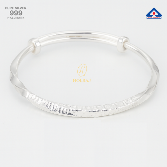 A handcrafted pure 999 silver bangle with rippled and twisted design, reflecting light on a white background – AgniRipple by Holraj.